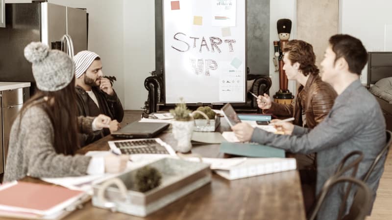 Startup team working together beside a Start Up poster